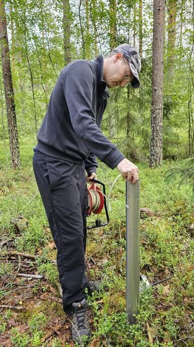 Measuring the groundwater level by hand.